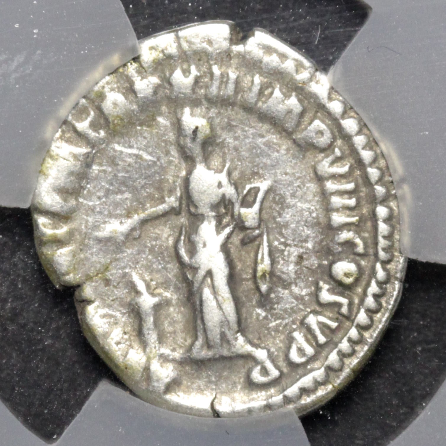 Ancient silver coin with a figure and inscriptions on a gray background