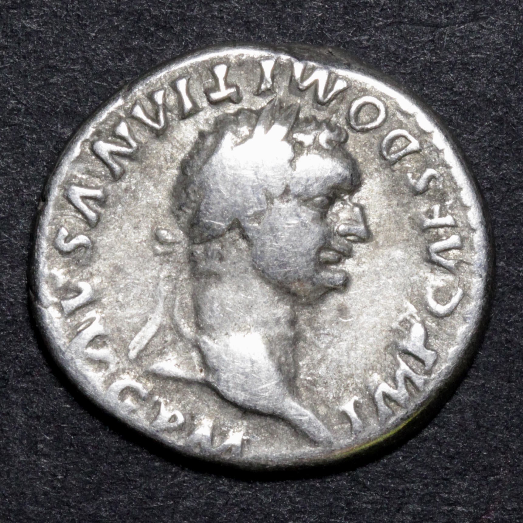 Ancient Roman coin with a profile of a emperor on a dark background