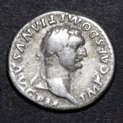 Ancient Roman coin with a profile of a emperor on a dark background
