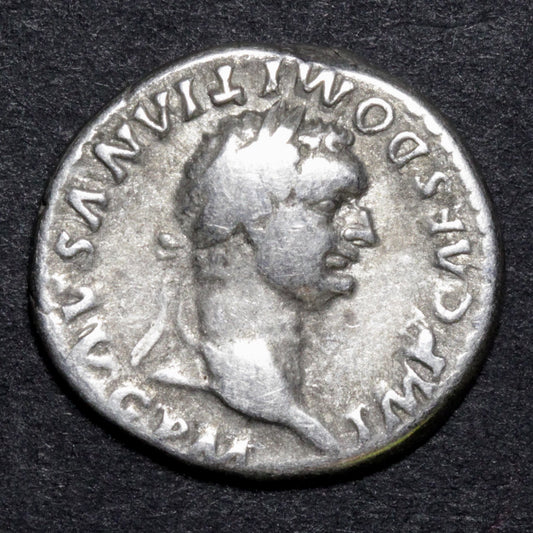 Ancient Roman coin with a profile of a emperor on a dark background
