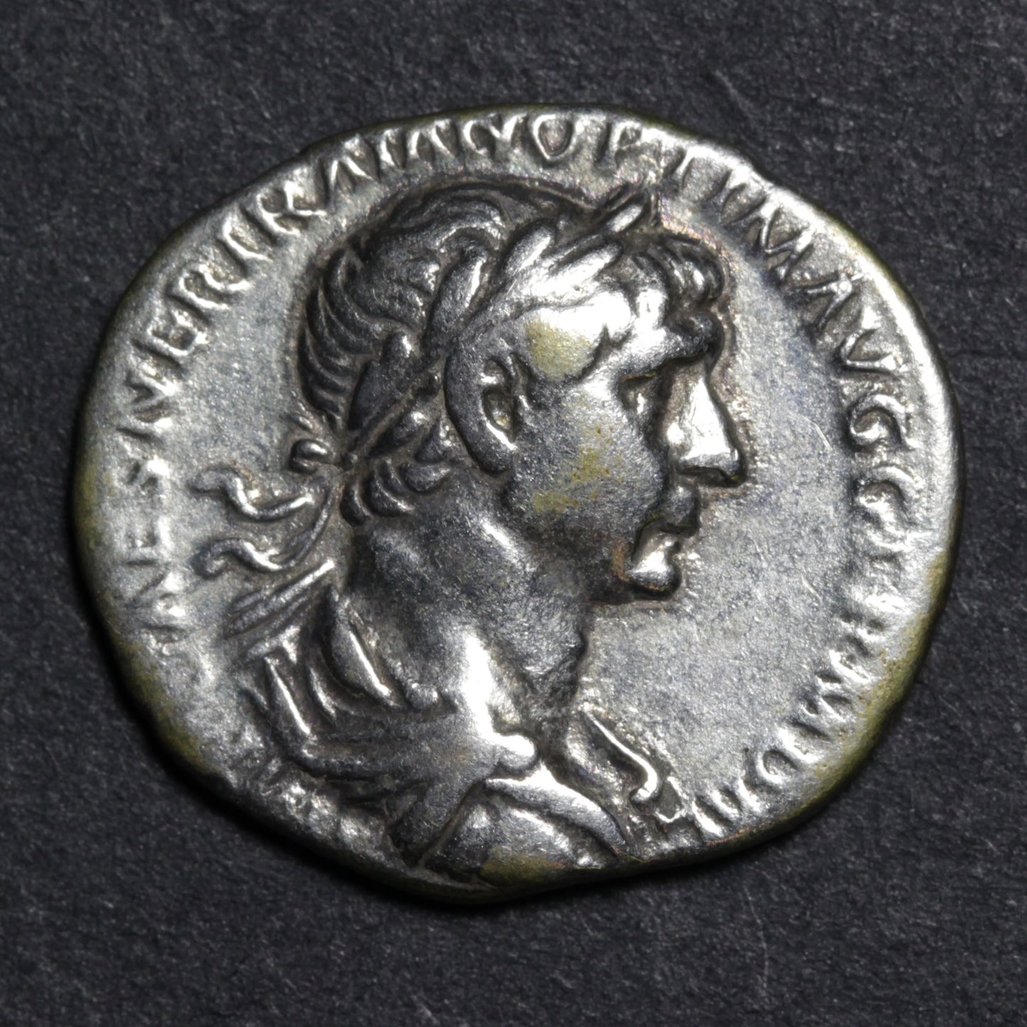 Ancient Roman coin with profile of a emperor on a dark background