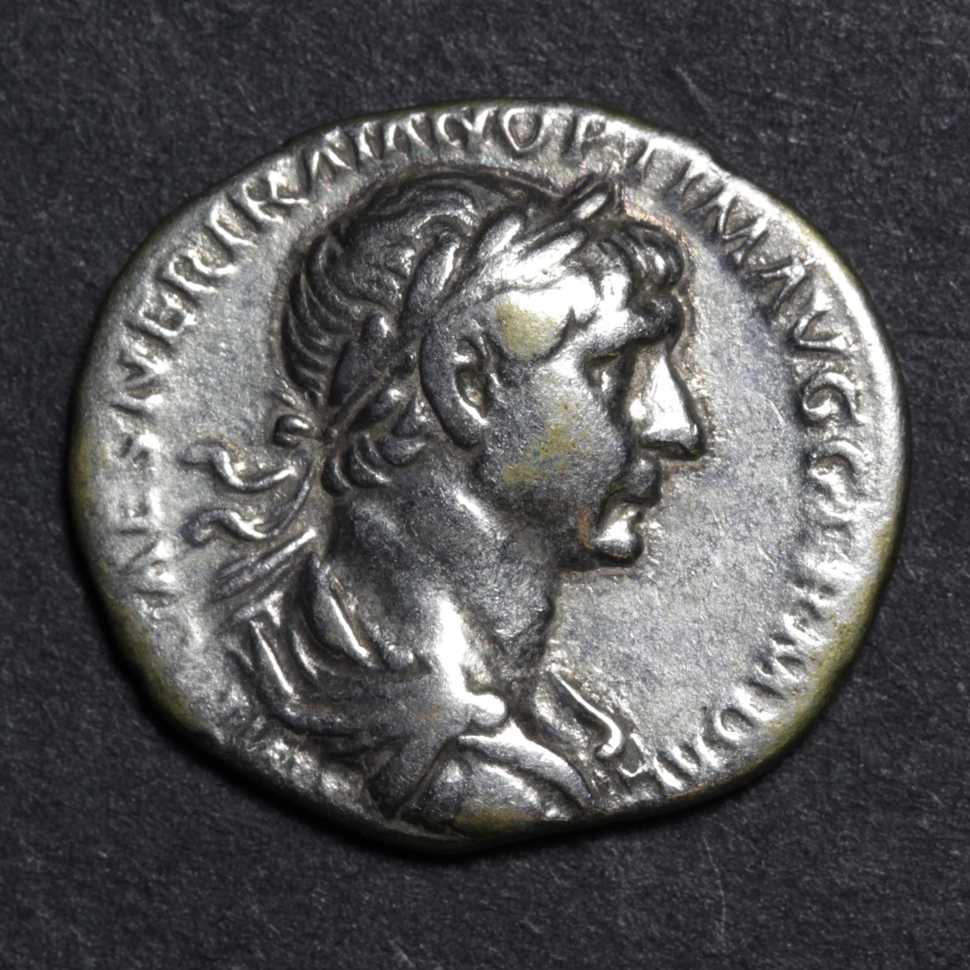 Ancient Roman coin with profile of a emperor on a dark background