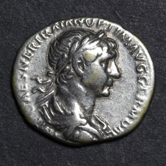 Ancient Roman coin with profile of a emperor on a dark background