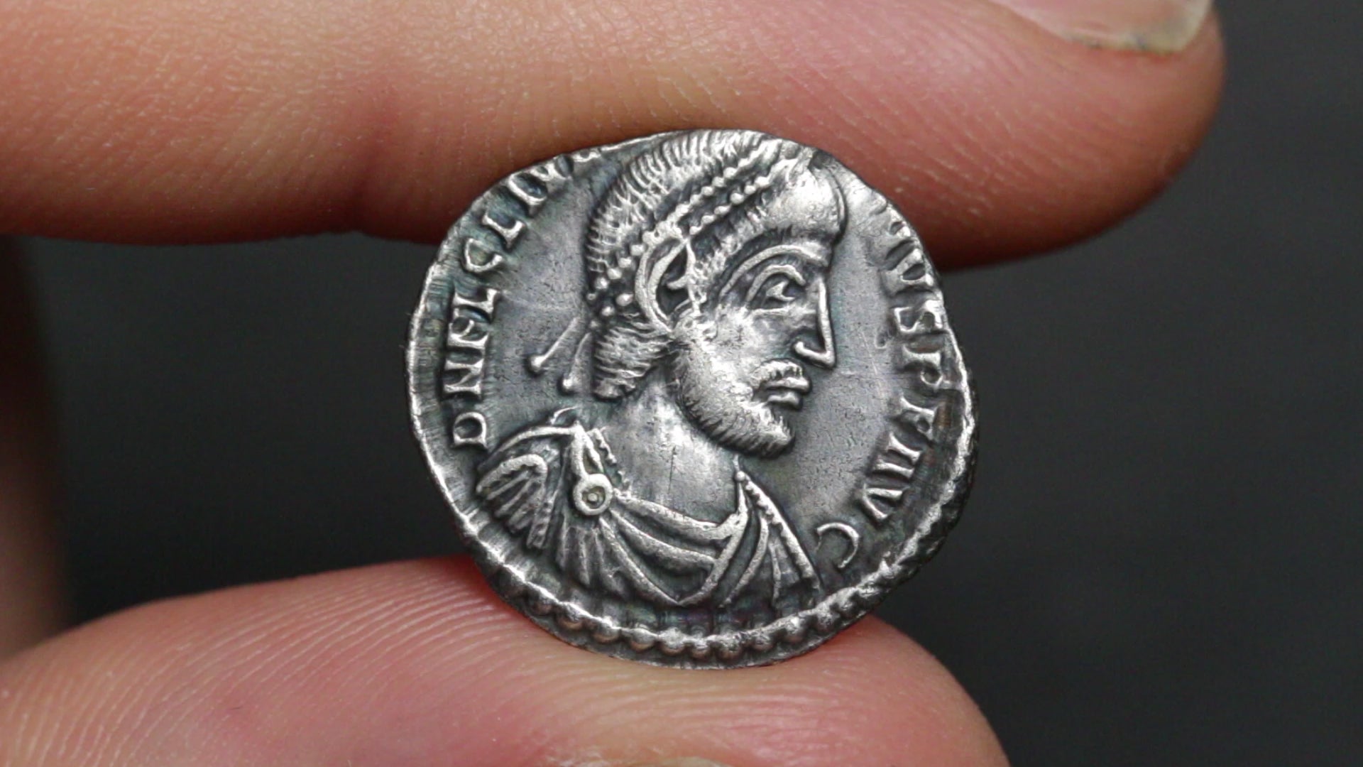 video of julian the apostate siliqua held between two fingers being rotated to show both sides
