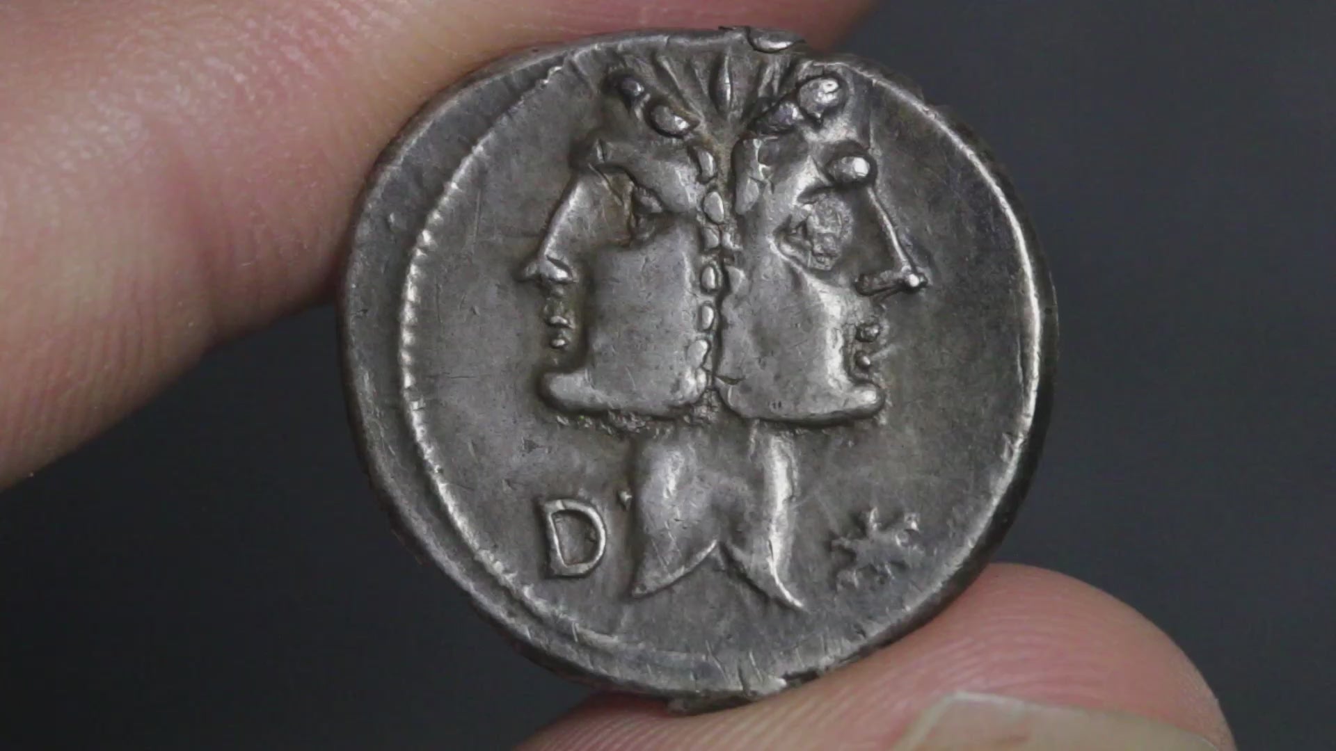video showing denarius being rotated between two fingers to show both sides