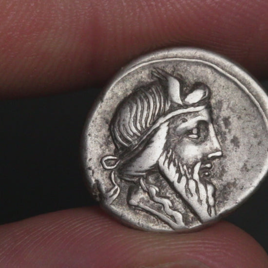 ancient coin being rotated between two fingers to show both sides