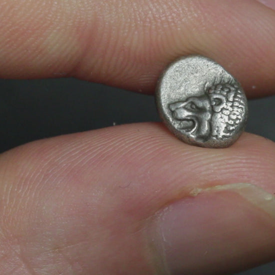 small silver coin being rotated to show both sides